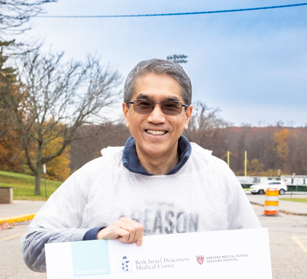 Dr. Eric T. Wong at Reason to Run, holding a sign