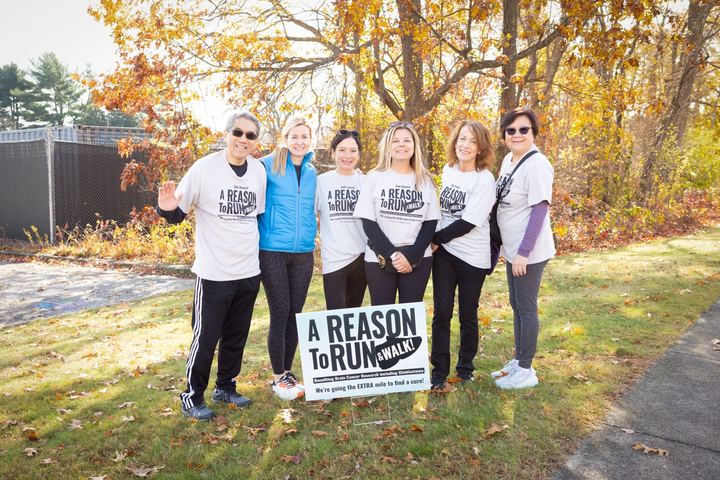 A group posed together holding an event sign