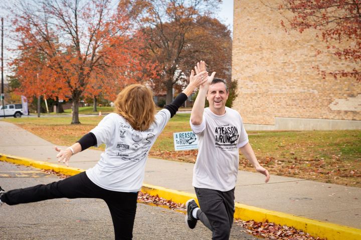 Two participants high-fiving mid-stride